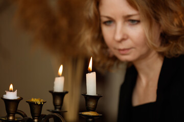 A woman is looking at three candles