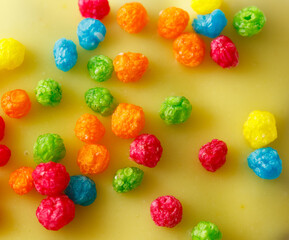 A yellow surface with a bunch of colorful cereal on it