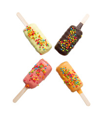 Four different colored ice cream sticks with sprinkles on top
