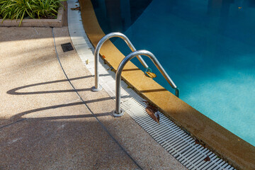 A pool with a ladder and a shadow on the ground