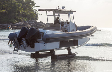 A boat on tracks moves along the beach