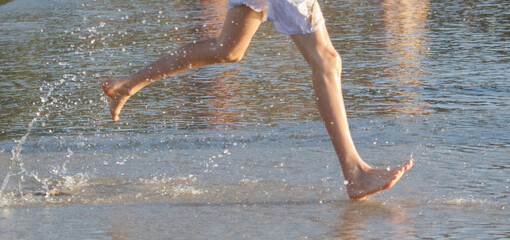 A person running in the water with their feet in the water