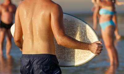 A man is holding a surfboard in the water