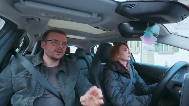 Man in passenger seat pointing and explaining directions to the driver &mdash; concept of human navigation, teamwork, or learning to drive.