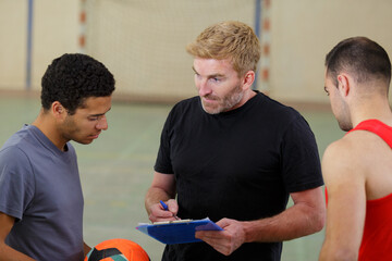 portrait of trainer writing with players
