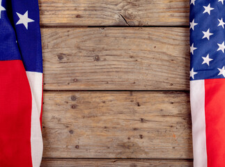 Overhead view of america flags with stars and stripes on wooden table along with copy space