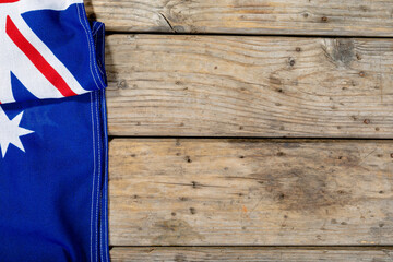 Overhead view of union jack and star on australia flag over wooden table with copy space