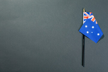 Stars and union jack on australia flag stick by copy space over black table