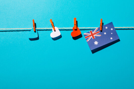 Heart shapes and australia flag hanging on clothesline with copy space over blue background