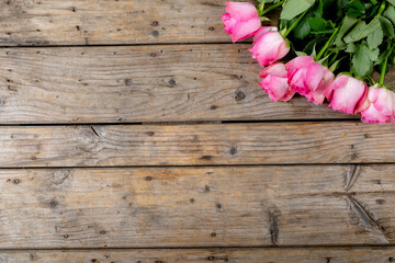 Overhead view of fresh pink tulip flowers bunch over wooden table with copy space