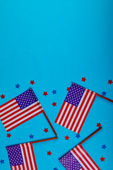Usa flag sticks with star shape confetti by copy space on blue background