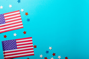Directly above view of usa flag sticks with star shape confetti by copy space on blue background