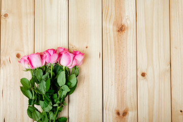 Directly shot of fresh pink roses on wooden table with copy space © wavebreak3