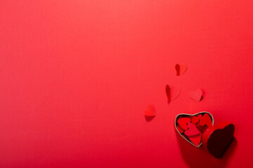 Overhead view of heart shaped decoration and gift box on red background, copy space