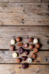 Directly above shot of chocolates arranged in heart shape with copy space on table