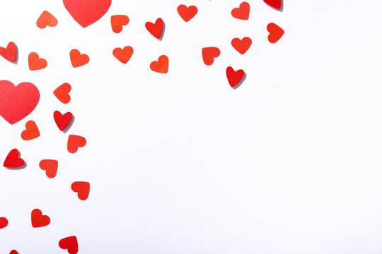Overhead view of red heart shaped decoration with copy space over white background