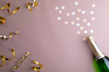 Overhead view of decoration and champagne bottle isolated on pink background, copy space