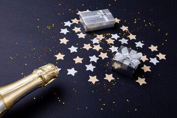 Champagne bottle with gift boxed and star shaped decoration on table, copy space