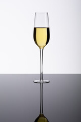 Champagne flute on glass table isolated over white background, copy space