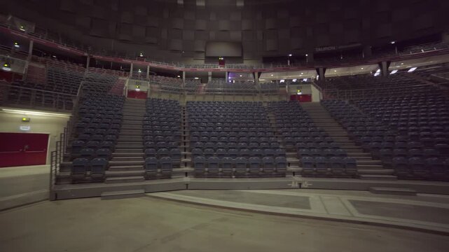 Curved layout of empty amphitheater reveals clean symmetry and massive scale. Modern music arena prepared for rehearsal public event