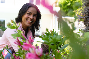Portrait of cheerful african american young woman gardening at backyard