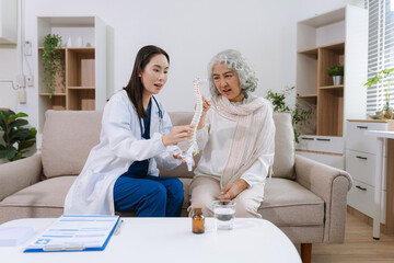 Doctor explains spine surgery using anatomical model, explaining symptoms and treatment to patients.