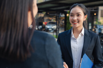Business women shake hands after agreeing to start a new project successfully.