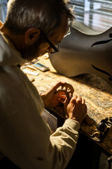 Crafting a Carbon Fiber Cello Under Warm Table Lamp Light in a Luthier's Workshop