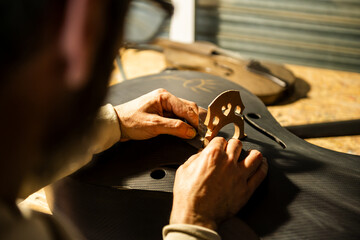 Close-up View of a Luthier Working on a Carbon Fiber Cello in a Workshop