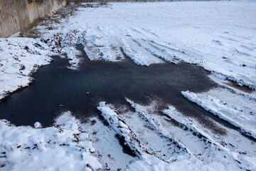A puddle of urea on a snowy manure pile