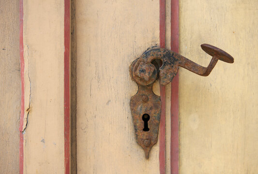 Rusty old metal door handle and keyhole in Austria