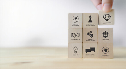 A hand arranging wooden blocks with business strategy and skill icons on a table top