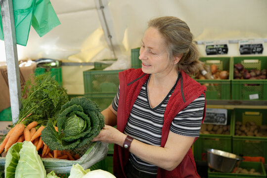 Market vendor with savoy cabbage at organic food stall in Wolfratshausen