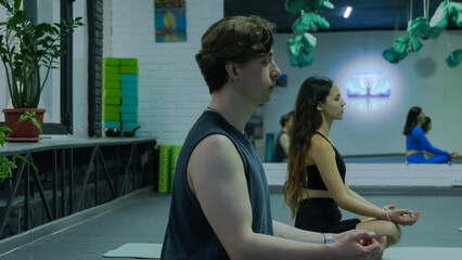 Man sitting in a yoga pose in a studio