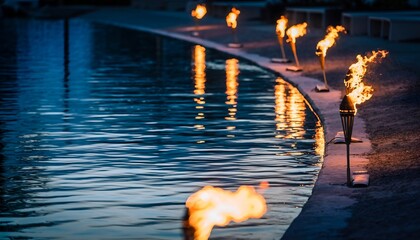 Torch flames reflecting in water at night creating mood and atmosphere