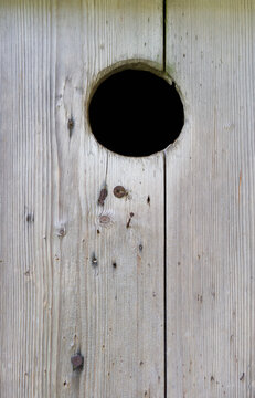 Hole on wooden door in Austria with rustic texture and wood grain