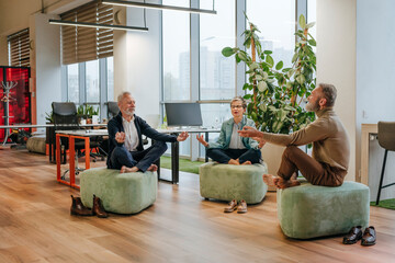 Business colleagues meditating and practicing yoga for relaxation in office