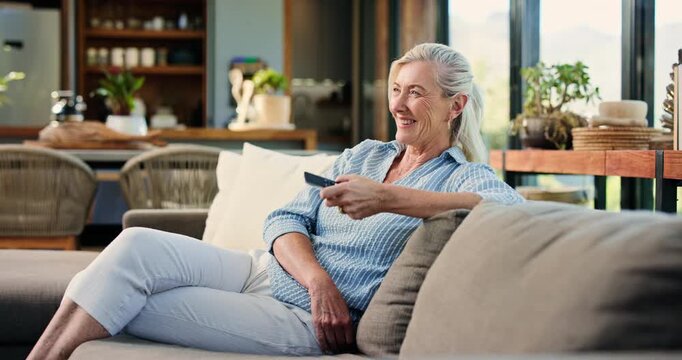 Laughing, woman and relax with remote on couch, entertainment and subscription for movie on website. Happy, mature person and change channel with controller, chilling and streaming funny film in home
