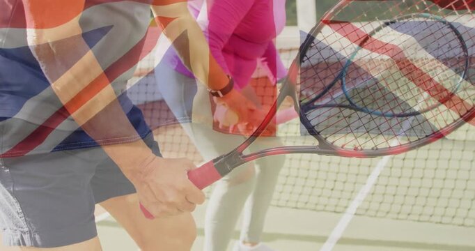 senior duo swinging rackets near net, holding balls, showing Union Jack overlay for sport marketing