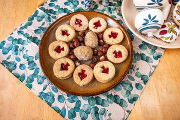 Linzer cookie and nut on plate, napkin and Christmas ball on plate.