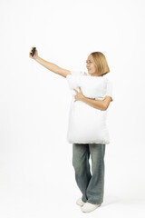 Young woman in a white sweatshirt holding a pillow