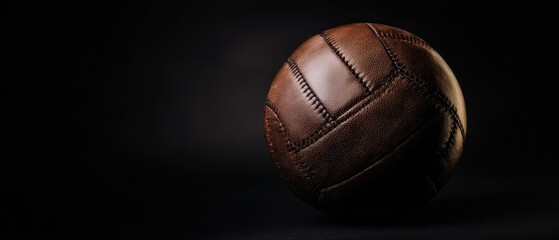The Vintage Leather Soccer Ball Resting on Dark Studio Background with Dramatic Lighting