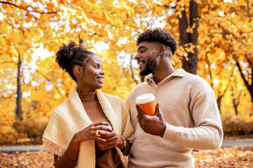 African American Couple Walking with Coffee in Autumn Park