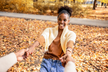 Couple Spinning Hand in Hand in Autumn Park