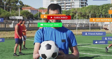 Animation of portrait of media icons over diverse male soccer players playing soccer at pitch - Powered by Adobe