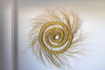 Decorative spiral wall art made from braided natural straw fibers