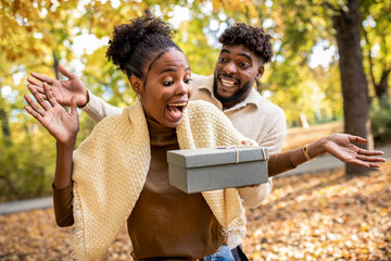 Couple Sharing a Sweet Surprise in Autumn Park