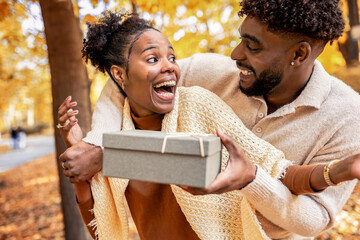 Couple Sharing a Sweet Surprise in Autumn Park