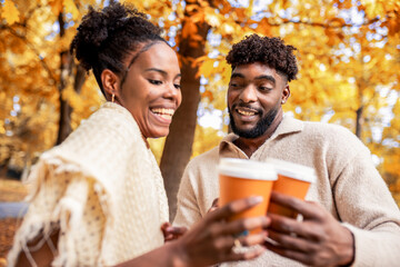African American Couple Walking with Coffee in Autumn Park