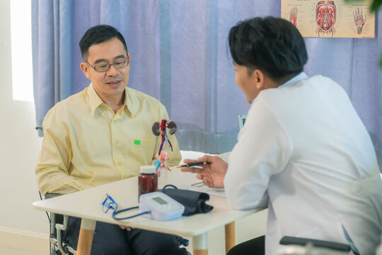 A male doctor sat at a table in a hospital, discussing models of the male urinary system, such as benign prostatic hyperplasia (BPH), prostatitis, and cystitis.